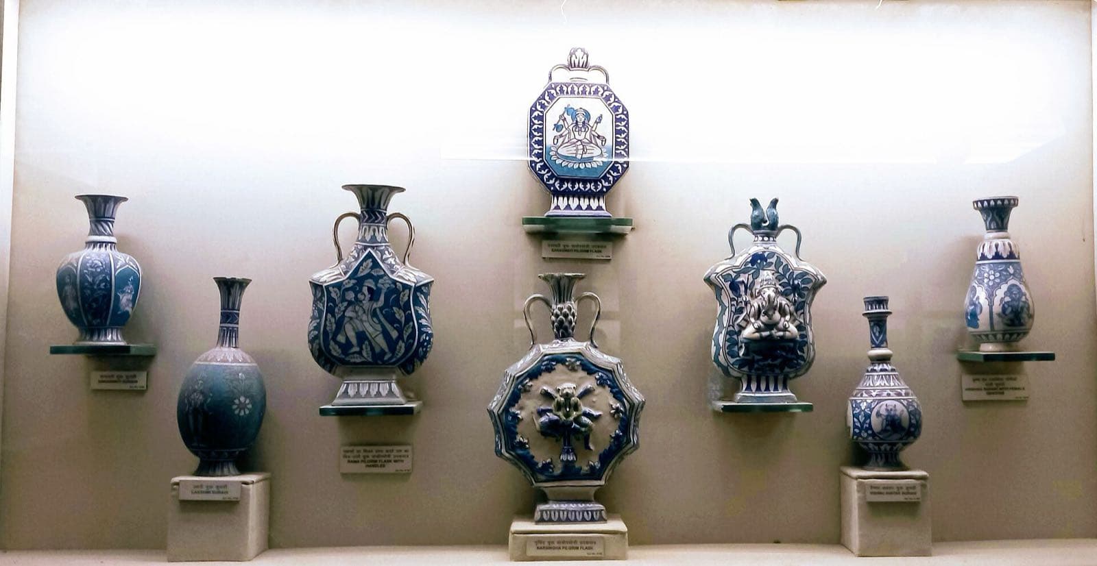 A museum display case of blue-and-white glazed vases, flasks and pilgrim bottles.